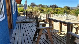 a wooden deck with a table and chairs and an umbrella at 100 Experiencias Chile, habitación 3 in Lagunillas