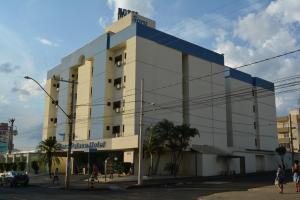 a large building with people walking in front of it at Sara Palace Hotel in Uberlândia