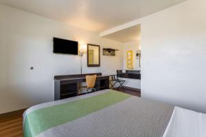 a small hotel room with a bed and a desk at Studio 6-El Paso, TX - East in Loma Terrace