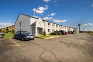 a large white building with cars parked in a parking lot at Motel 6-Rothschild, WI in Rothschild