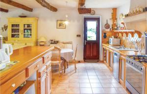 a kitchen with a table and a dining room at Gorgeous Home In Trégunc With Kitchen in Kerguillaouet