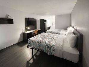 Habitación de hotel con 2 camas y escritorio en Studio 6 Altoona IA Des Moines East, en Altoona