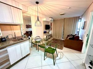 a kitchen with a table and chairs and a living room at LANDSCAPE - Beira mar platinum in Fortaleza