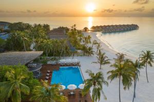 ダンゲシにあるOutrigger Maldives Maafushivaru Resortのプールと海を望むリゾートの空からの景色を望めます。