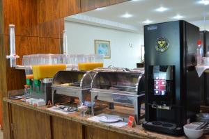a kitchen with a counter with glasses of orange juice at Sara Palace Hotel in Uberlândia