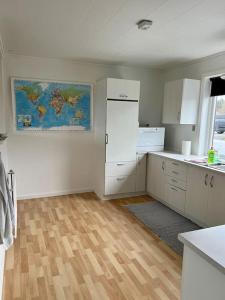 a kitchen with white cabinets and a map on the wall at Apartment in the center of Tórshavn, free parking. in Tórshavn