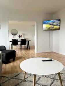 a living room with a white table and a dining room at Apartment in the center of Tórshavn, free parking. in Tórshavn
