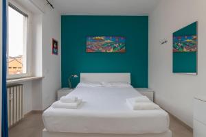 a bedroom with a white bed with a blue wall at [Luxury apartment near Navigli] Carlo D'adda 29 in Milan