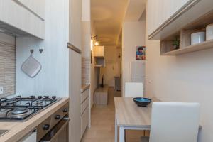 uma cozinha com um fogão e alguns armários brancos em [Luxury apartment near Navigli] Carlo D'adda 29 em Milão