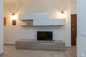 uma sala de estar com uma televisão de ecrã plano num centro de entretenimento em [Luxury apartment near Navigli] Carlo D'adda 29 em Milão