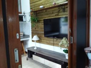 sala de estar con TV en una pared de madera en Residencial Viva o Verde Casa, en Florianópolis