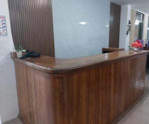a wooden reception counter in a lobby with flowers at Hotel Islas Galapagos in Puerto Baquerizo Moreno