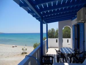 a balcony with a table and chairs and the beach at Paradise Studios in Agiassos
