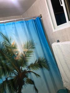 einem blauen Duschvorhang mit einer Palme in der Unterkunft Hermoso Apartamento Carmen Renata III in Pantoja