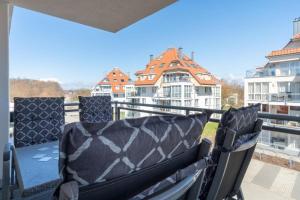 a balcony with two chairs and a view of buildings at Strandpark-Grossenbrode-Haus-Moewennest-Wohnung-8-Typ-2 in Großenbrode