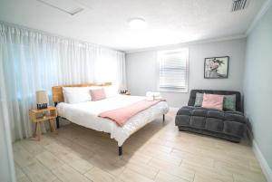 een slaapkamer met een bed en een bank erin bij Tranquil & Fully Renoveted Home Near Busch Gardens in Tampa