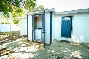 una puerta azul en una casa blanca con un patio en Tranquil & Fully Renoveted Home Near Busch Gardens, en Tampa
