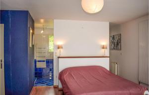 een slaapkamer met een rood bed en een badkamer bij Cozy Home In Lhon With Wifi in Léhon