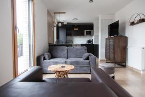 a living room with a couch and a table at Appart Chic & Elégant-Métro 7 Leo-Lagrange+Parking in Villejuif