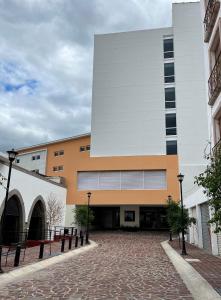 duży budynek z ceglaną drogą przed nim w obiekcie Hotel Refugio w mieście San Juan de los Lagos
