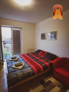 - une chambre avec un lit et une chaise rouge dans l'établissement Apartman 8, à Valjevo