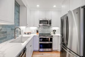 a kitchen with white cabinets and a stainless steel refrigerator at Just Walk Inn Townhome: Stroll To Main St, Gondola in Breckenridge +28 photos