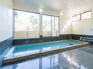 a swimming pool in a room with a large window at SUIHOUEN in Numazu
