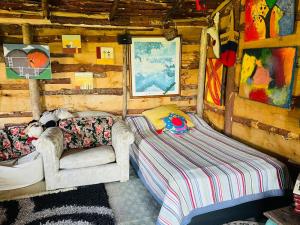 Habitación con sofá y cama en una cabaña en Cabaña Rústica Villa Alicia, en Paipa