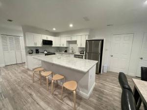 a kitchen with a large counter and stools in it at 7326 Lake View Bungallow-5 Minutes Universal in Orlando
