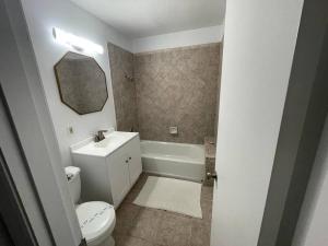 a bathroom with a toilet and a sink and a tub at 7326 Lake View Bungallow-5 Minutes Universal in Orlando