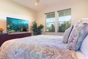 a bedroom with a large bed and a fish tank at Hali'i Kai 3B in Waikoloa