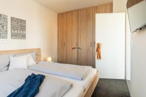 1 dormitorio con 1 cama y armario de madera en Strandpark-Grossenbrode-Haus-Leuchtturm-Wohnung-14-Leuchtturmblick, en Großenbrode