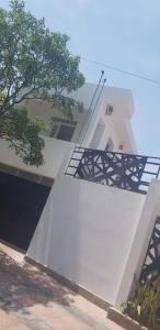 a white building with a tree on the side of it at Alborada in San Fernando del Valle de Catamarca