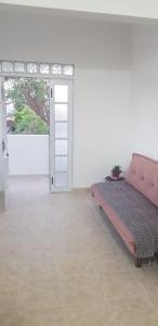 a bedroom with a pink bed in a white room at Alborada in San Fernando del Valle de Catamarca