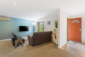 uma sala de estar com um sofá e uma televisão em The Blue Bay em Inverloch