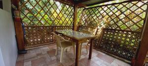 a table and chairs in a gazebo with a window at Bat Tree Cottages in Agoho