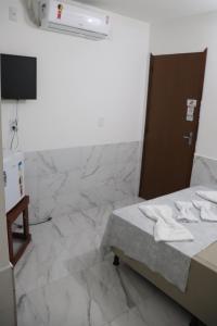 een kamer met een bed, een tv en marmeren vloeren bij Suítes Mar de Maragogi in Maragogi +32 foto's