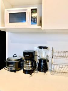 a kitchen counter with a blender and a microwave at Único Apartamento en Nuevo y Moderno Condominio in San José