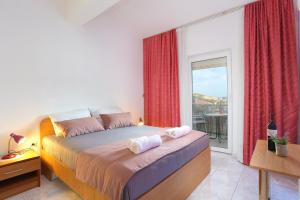 Schlafzimmer mit einem Bett mit roten Vorhängen und einem Fenster in der Unterkunft Twin Room Marina 5953a in Marina