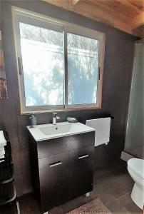 a bathroom with a sink and a window at 100 Experiencias Chile, habitación 3 in Lagunillas