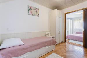 1 dormitorio con cama y espejo en Apartments by the sea Zivogosce - Porat, Makarska - 6899, en Igrane