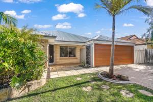 una casa con una palmera en el patio en Halls Head Haven en Mandurah