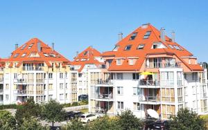 una fila de edificios de apartamentos con techos naranjas en Strandpark-Grossenbrode-Haus-Seestern-Wohnung-38-Strandoase-im-Strandpark, en Großenbrode