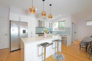 a kitchen with white walls and stainless steel appliances at Melbourne Luxury Villa at Doncaster in Nunawading