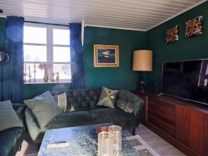 a living room with a couch and a tv at Holiday home Gilleleje LXXV in Gilleleje