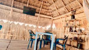a table and chairs in a straw hut at Estrella de mar in Cabo de la Vela