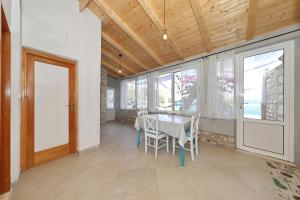 a dining room with a table and some windows at Secluded fisherman's cottage Cove Stiniva, Korcula - 11389 in Vela Luka