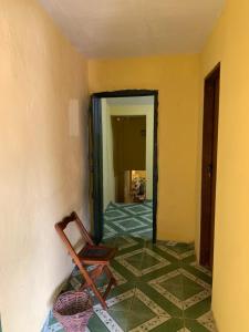 Habitación con silla y suelo de baldosa. en Quinca’s Hostel, en Lençóis