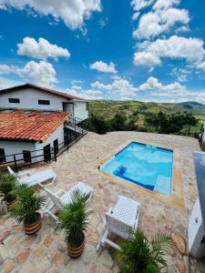 a patio with a swimming pool and a house at Casa Luna Hotel Campestre & Spa in San Gil