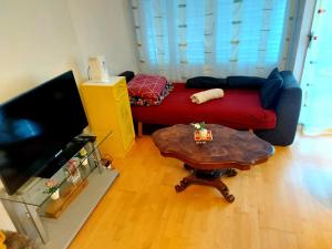 Sala de estar con sofá rojo y mesa de centro en Ferienwohnung in Zentrale Lage, en Berna